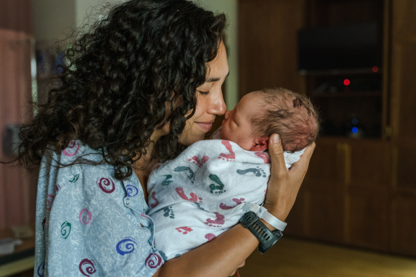 mom hugging newborn in hospital